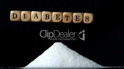 Dice spelling diabetes falling over a pile of sugar