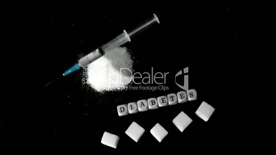 Syringe falling into pile of sugar besides white dice spelling out diabetes and sugar cubes