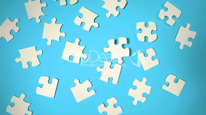 Jigsaw puzzle falling on blue surface