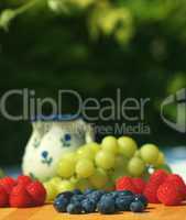 Blueberries, raspberries and grapes on garden table