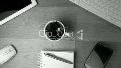 Two sugar cubes falling into cup of coffee and splashing a keyboard in black and white