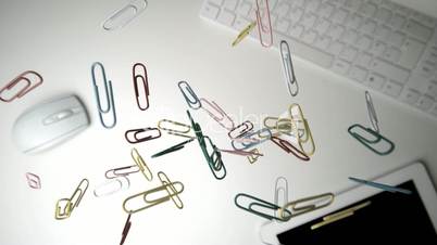 Paperclips falling over keyboard mouse and tablet pc