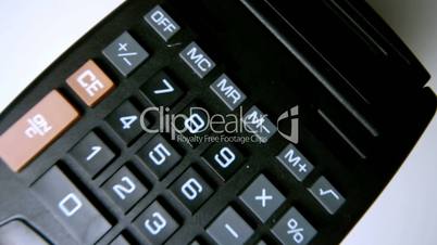 Black calculator falling on white surface