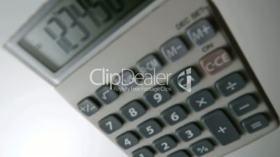 Pocket calculator falling on white surface