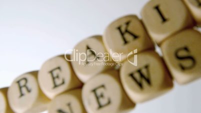 Breaking news spelled out in dice falling on white surface