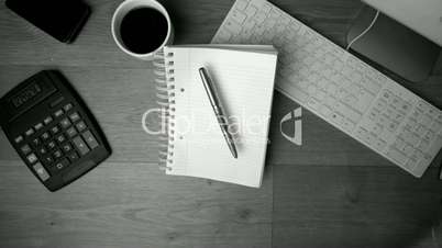 Fountain pen and notepad falling on office desk