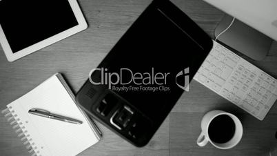 Smartphone falling onto office desk in black and white