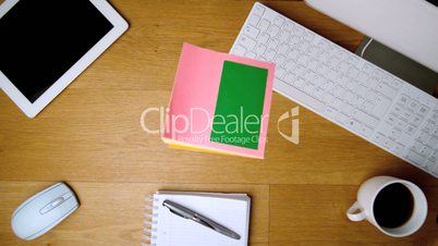 Pink sticky notes with chroma key falling on office desk