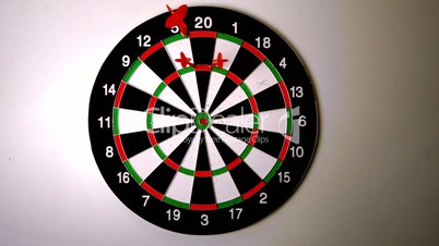 Dart hitting the dart board between two other darts