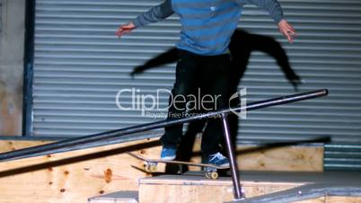 Skater doing crook slide down rail