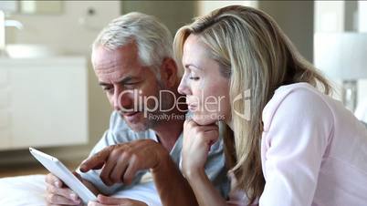 Couple using tablet together in bed