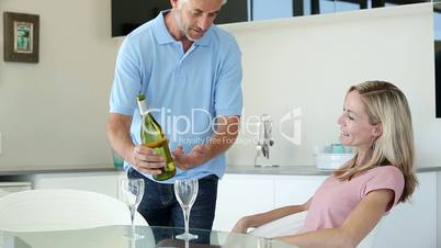 Man pretending to be waiter pouring a glass of wine for partner