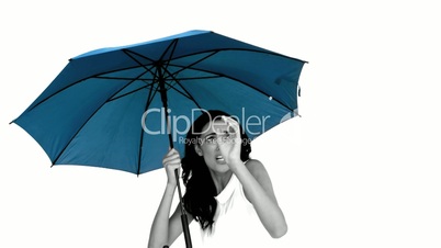 Woman under blue umbrella cowering with fear