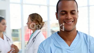 Nurse smiling and standing in front of medical team
