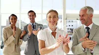 Business people clapping at  the camera