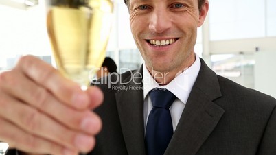 Confident business man raising a glass