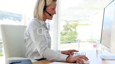 Blonde haired businesswoman working with a headset