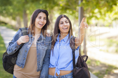 Mixed Race Twin Sisters Wearing Backpacks and Pointing Outside