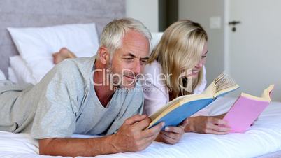 Couple reading books together in the bed 