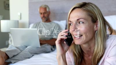 Woman hanging up the phone and talking to her husband
