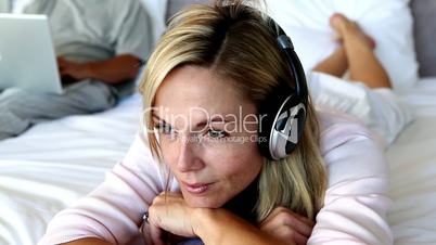 Calm woman closing her eyes while listening to music 