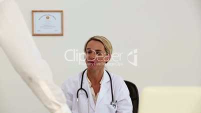 Female doctor asks a patient to sit down