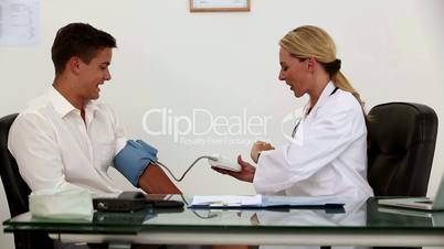 Female doctor checking patient blood pressure