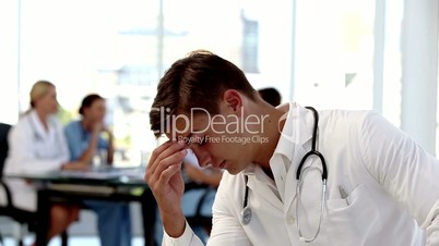 Young worried doctor holding his head 