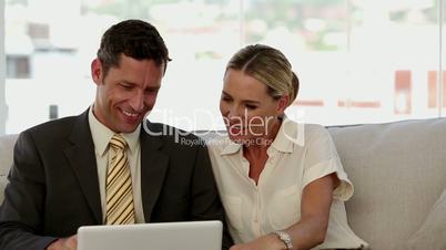 Laughing colleagues looking at a laptop