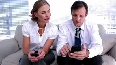 Businesswoman showing colleague how to work smartphone