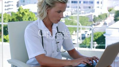 Nurse typing at her desk