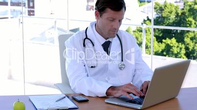 Doctor typing at his desk