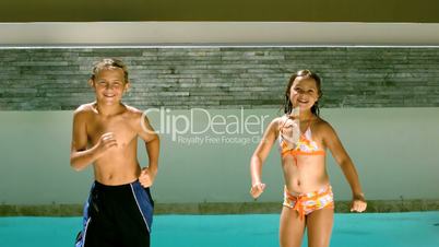 Siblings dancing and diving into the swimming pool