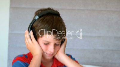 Dancing young boy enjoying music with headphones
