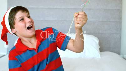 Happy boy using party popper in the bedroom