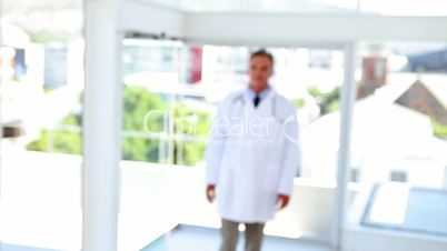 Doctor walking into focus and smiling
