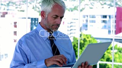 Businessman using his tablet and smiling