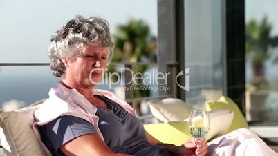 Mature woman enjoying glass of wine on balcony