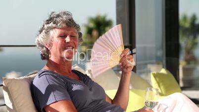 Woman fanning herself on the balcony