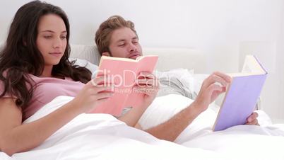 Couple reading books in bed