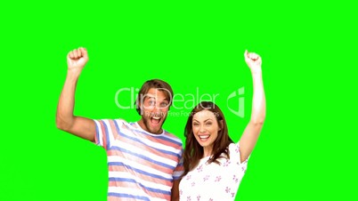 Two friends raising their arms on a green screen