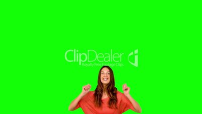 Woman jumping with arms raised on green screen