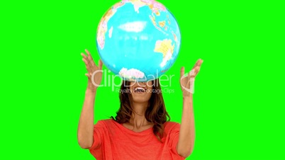 Woman throwing a globe on green screen