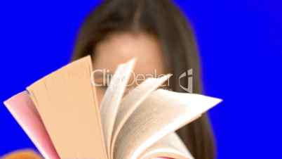 Woman flipping through a pink book on blue screen