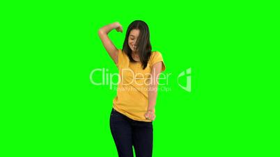 Woman dancing with arms raised on green screen
