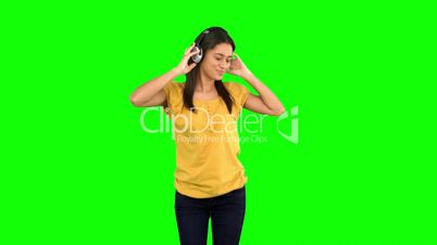 Woman dancing with headphones on green screen