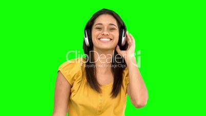 Woman smiling and listening to music on green screen