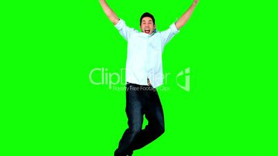 Young man jumping on green screen