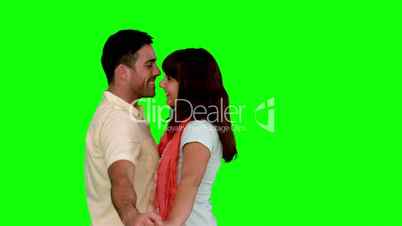 Young couple cuddling on green screen