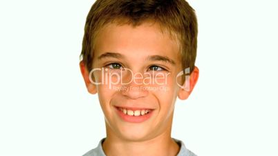 Little boy squinting against white background